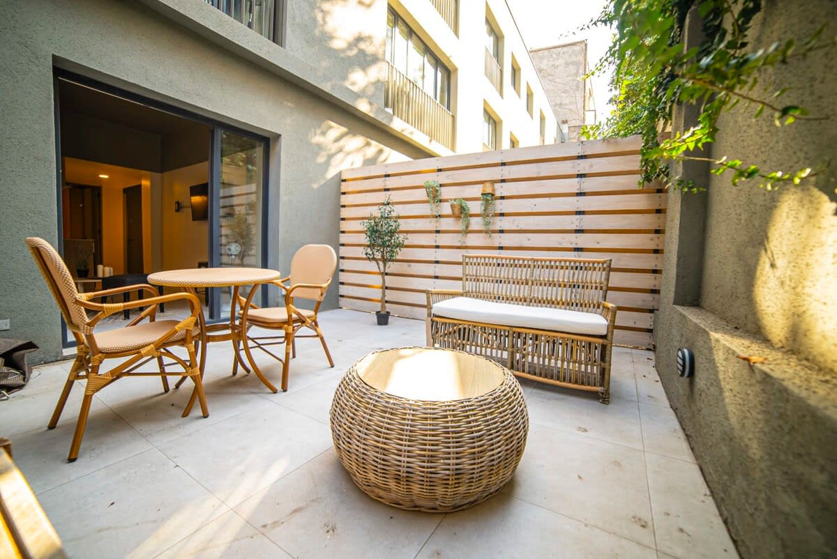 Relax in your private patio oasis with stylish wicker furniture and lush greenery, perfect for unwinding after a day of exploring.