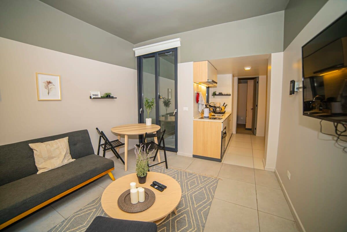 Cozy living area with modern decor and a functional kitchenette, perfect for relaxing or enjoying a meal.