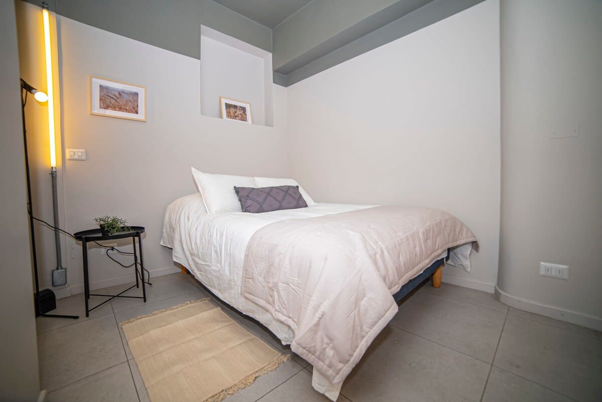 Relax in this cozy bedroom with soft lighting and stylish decor, perfect for a restful night's sleep.