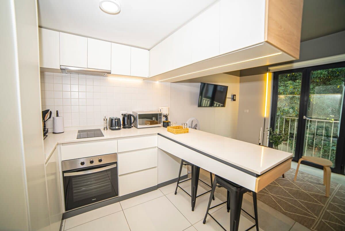 Sleek and modern kitchen with bar seating, perfect for enjoying a meal or morning coffee.