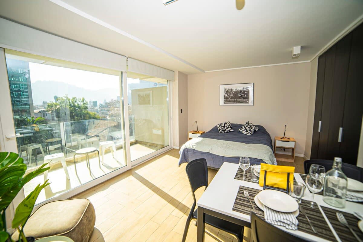 Bright and modern studio with stunning city views from a private balcony, perfect for a cozy getaway.