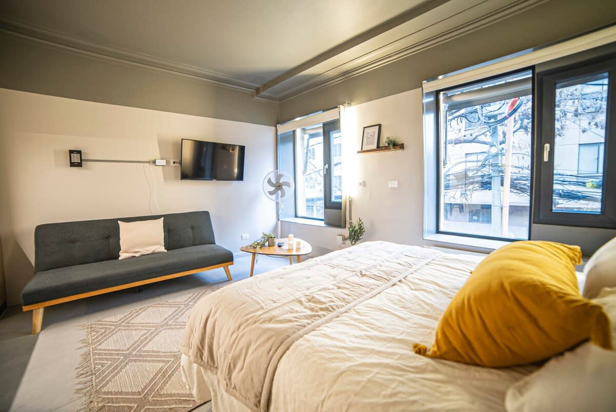 Bright and cozy bedroom with modern amenities and natural light, perfect for a relaxing stay.