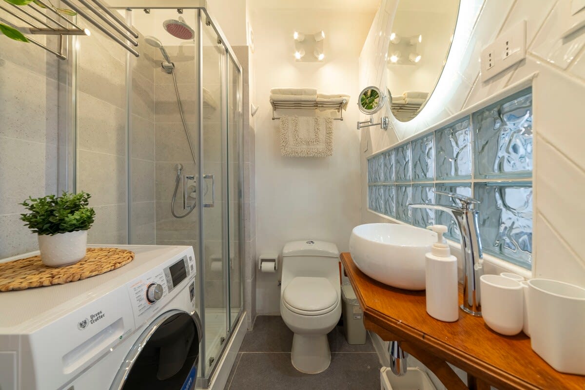 Modern bathroom with sleek fixtures and in-unit laundry, perfect for a comfortable stay.