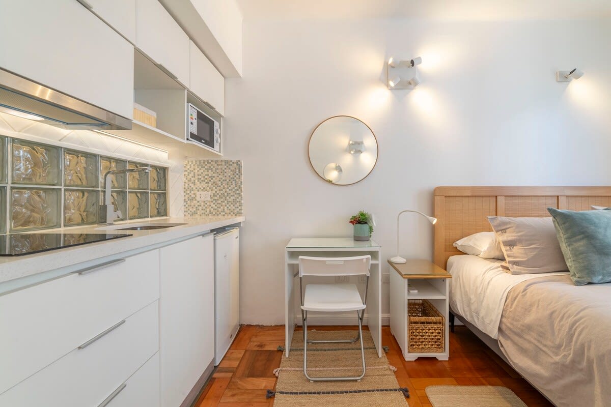 Cozy studio with modern kitchenette and inviting sleeping area, perfect for a relaxing stay in the heart of the city.