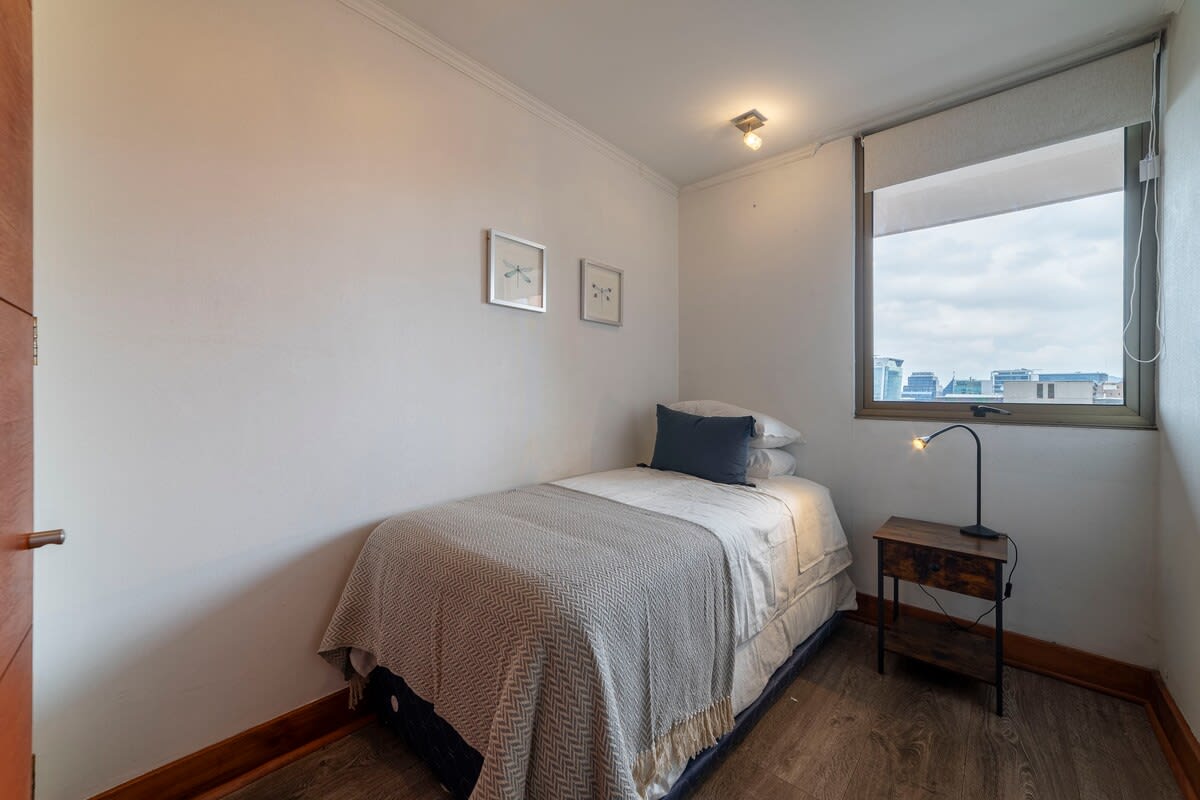 Cozy bedroom with city views, perfect for a restful stay in the heart of Chile.