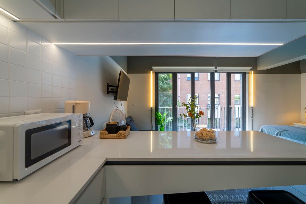 Bright and modern kitchen with sleek appliances and a view, perfect for cozy meals.