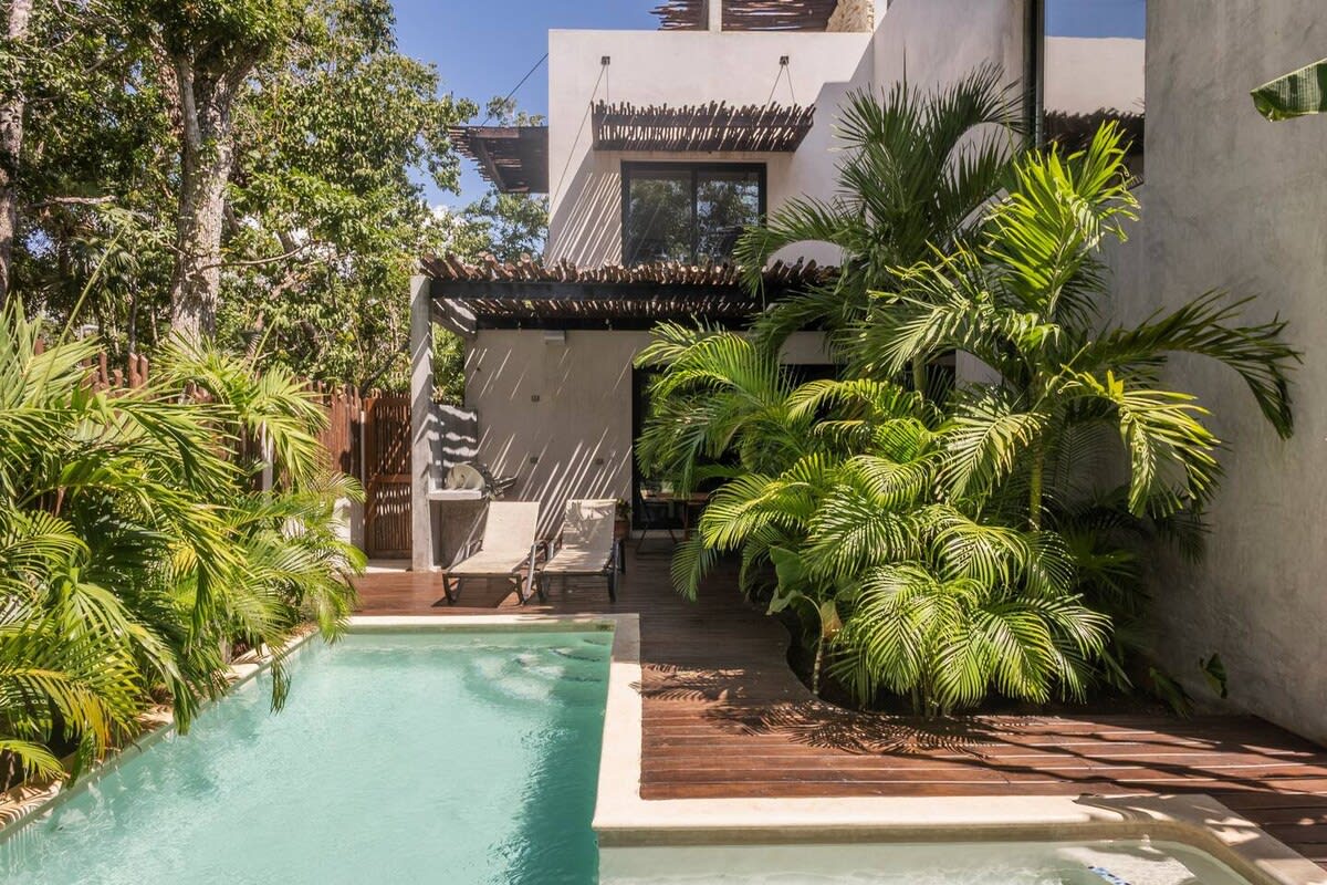 Main floor pool, surrounded by lush greenery. With sun loungers, outdoor dining and BBQ