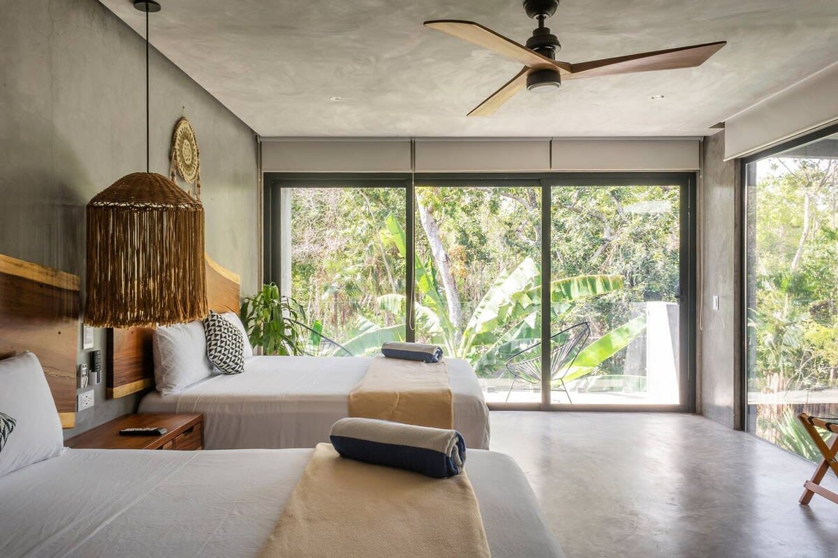 Bedroom 3, featuring two queen beds and private balcony access
