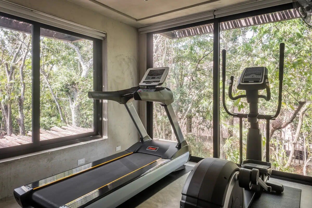 Fitness room, equipped with cardio machines and dumbbells