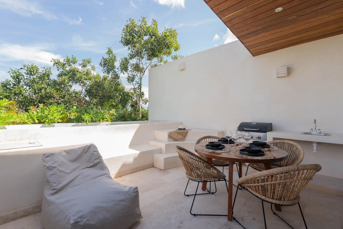 Outdoor patio with a dining area, grill, and plunge pool.