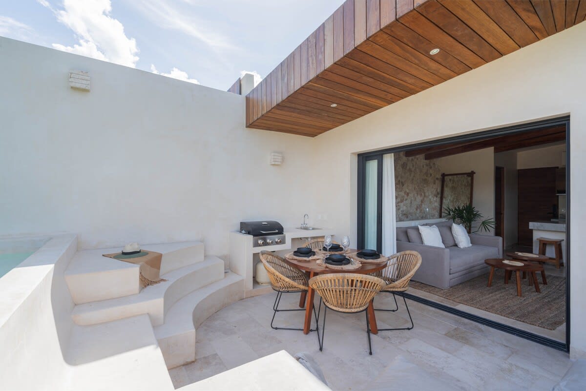 Patio of the penthouse, with a plunge pool, outdoor dining area, and grill.