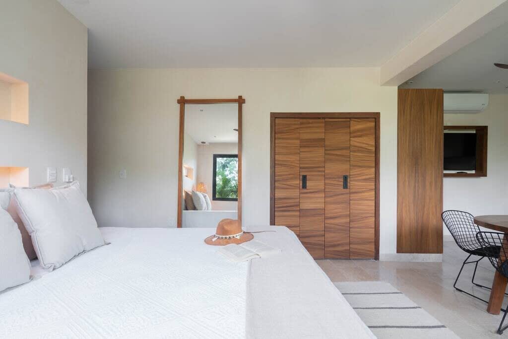 Bedroom #2 with en suite kitchen, dining table, sofa and smart tv. Features air conditioner and fan.