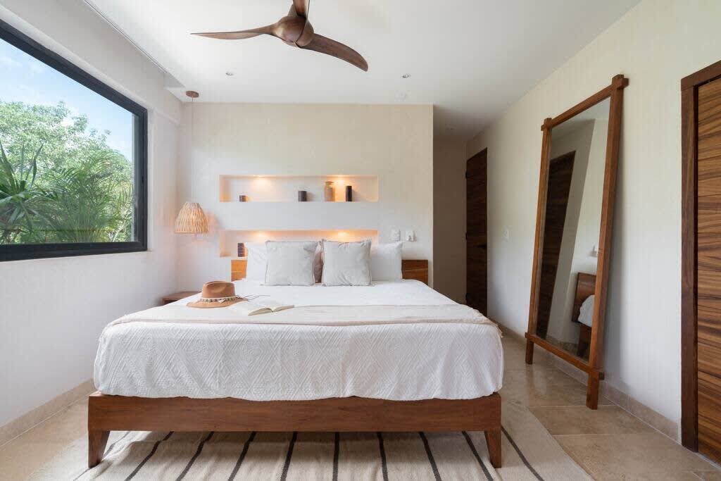 Bedroom #2 with en suite kitchen, dining table, sofa and smart tv. Features air conditioner and fan.