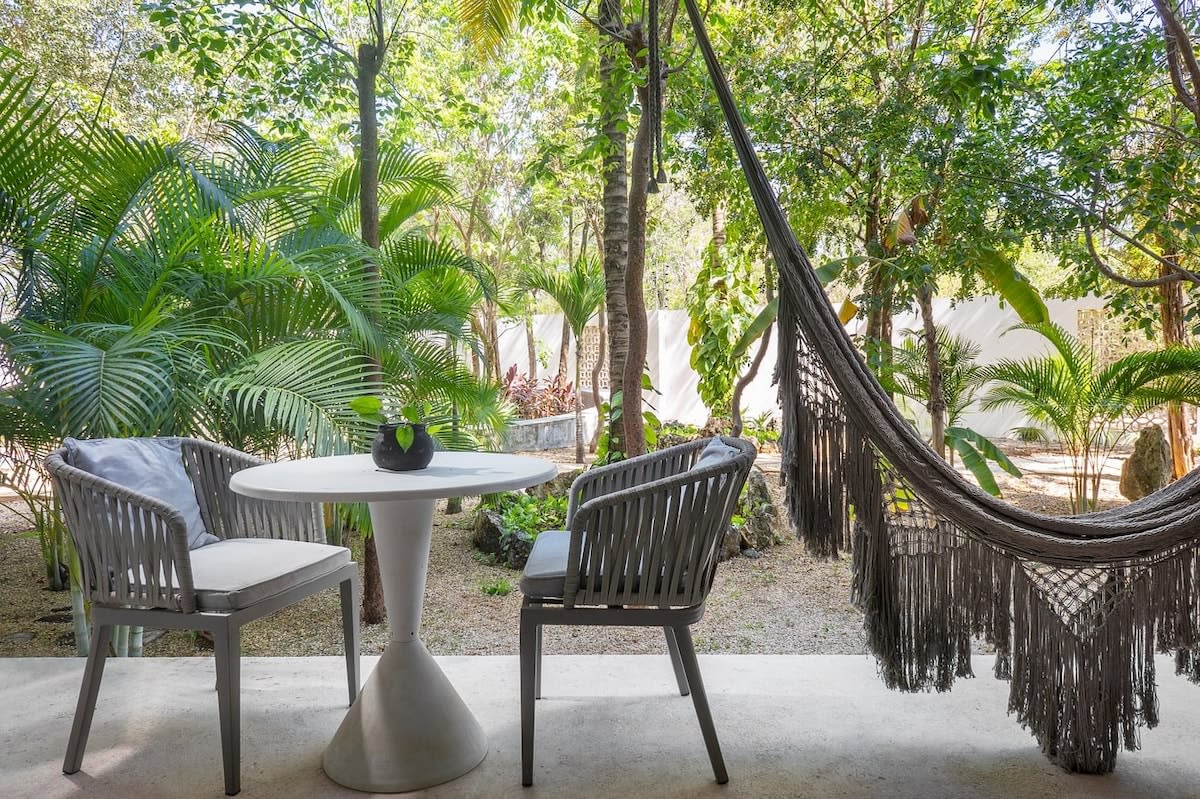 Small patio with an outdoor dining area and hammock.