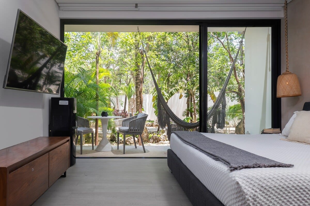 King-size bed, TV, and large windows with an exterior view.