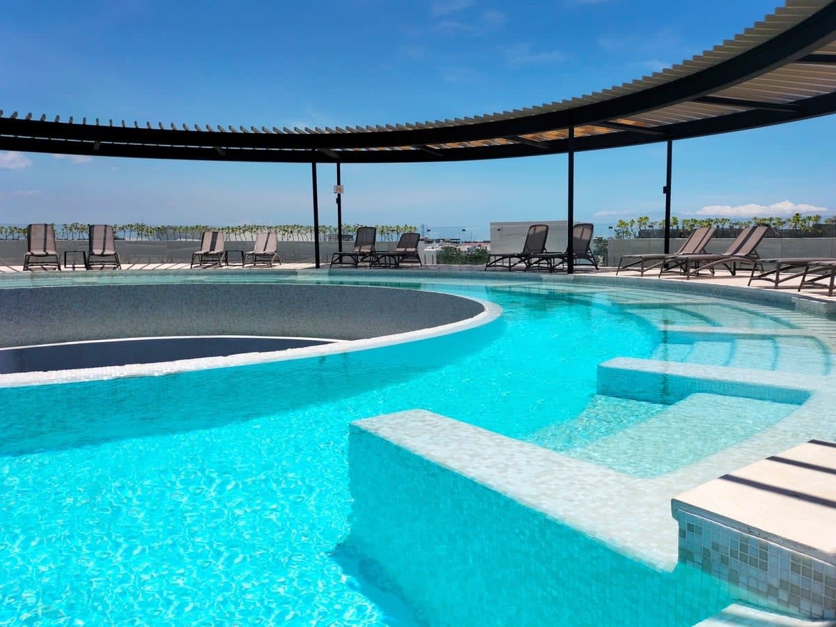 Pool located on the terrace in a circular shape, with lounge chairs.