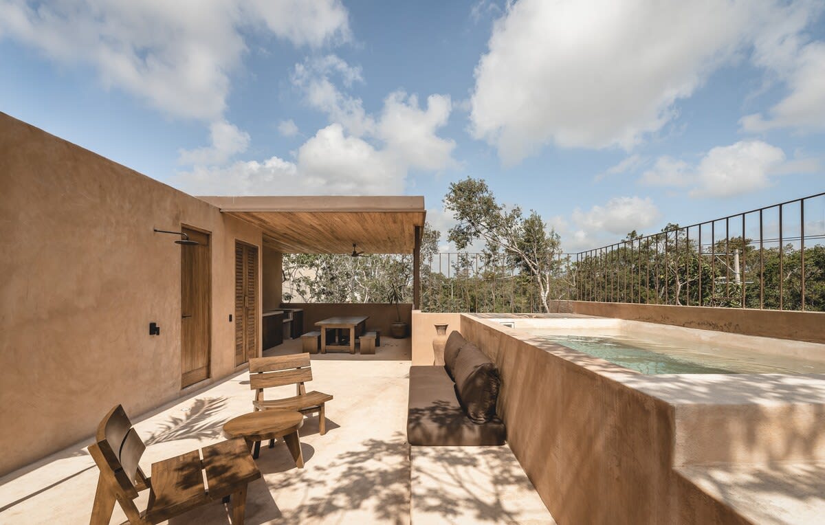 Private rooftop pool drenched in sunlight, featuring lounge space, outdoor dining area, grill, mini fridge, half bathroom and outdoor shower