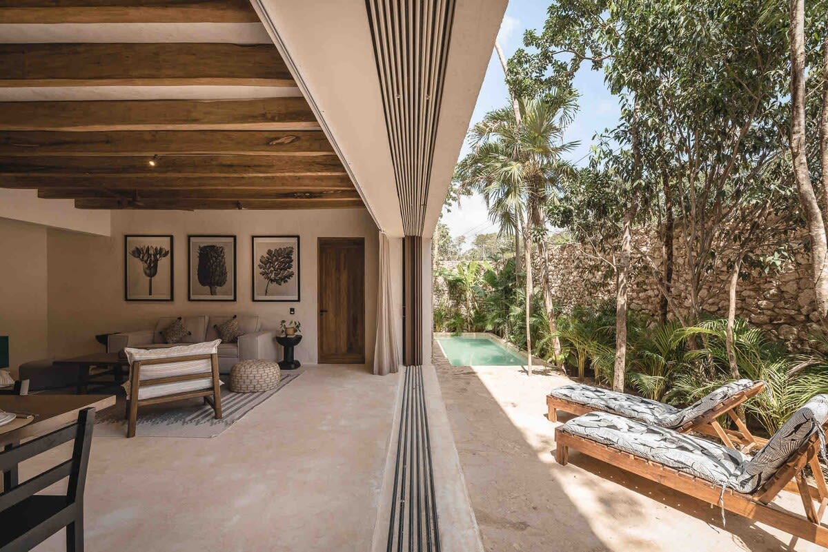 Floor-to-ceiling windows flooding the living and dining area with natural light 