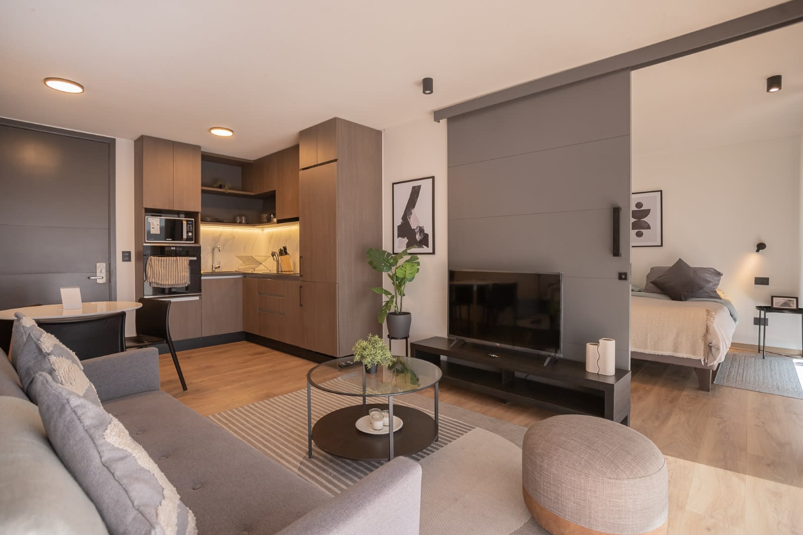 Experience modern comfort in this stylish open-plan living area, complete with a sleek kitchen and cozy bedroom retreat.
