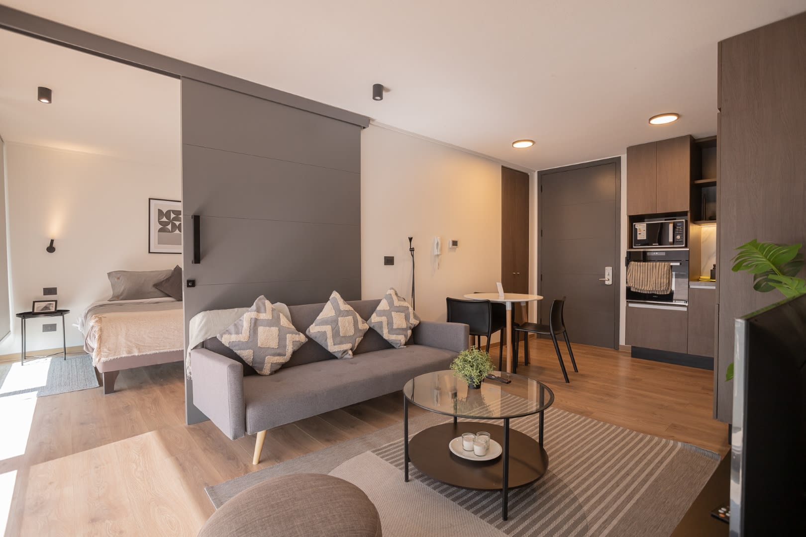 Modern open-plan living with cozy seating and sleek kitchen, perfect for a comfortable stay.