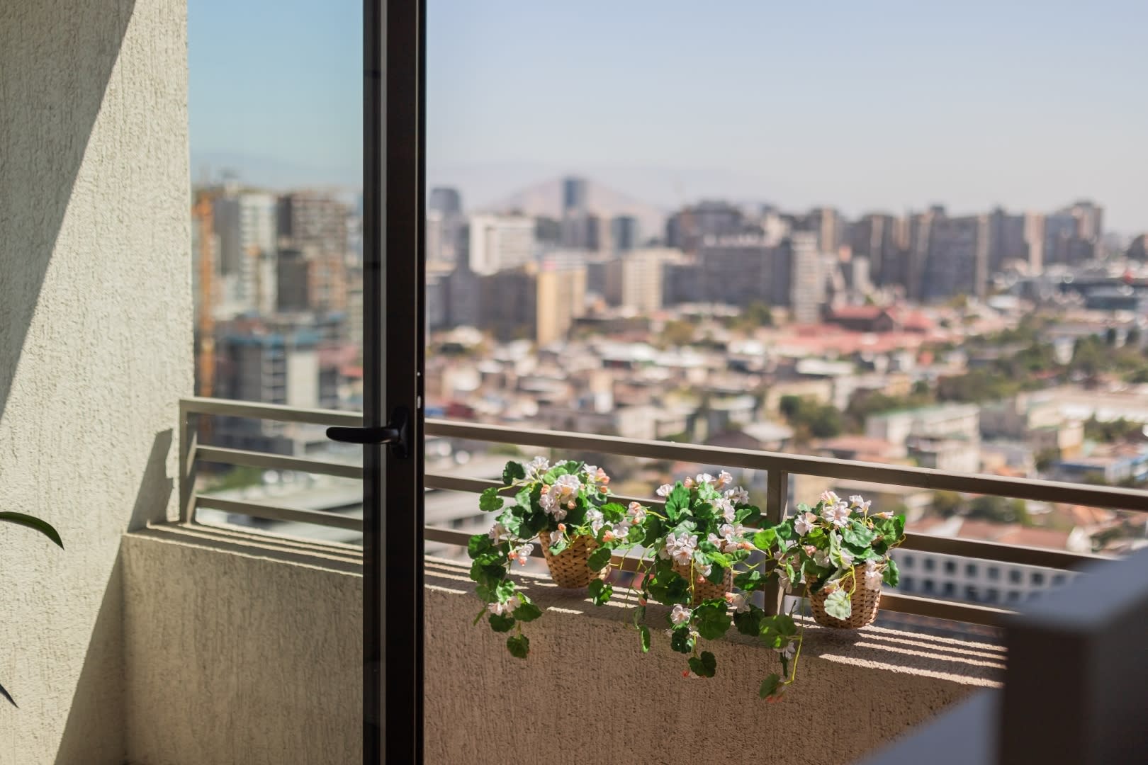 Enjoy breathtaking city views from your private balcony adorned with charming floral arrangements.