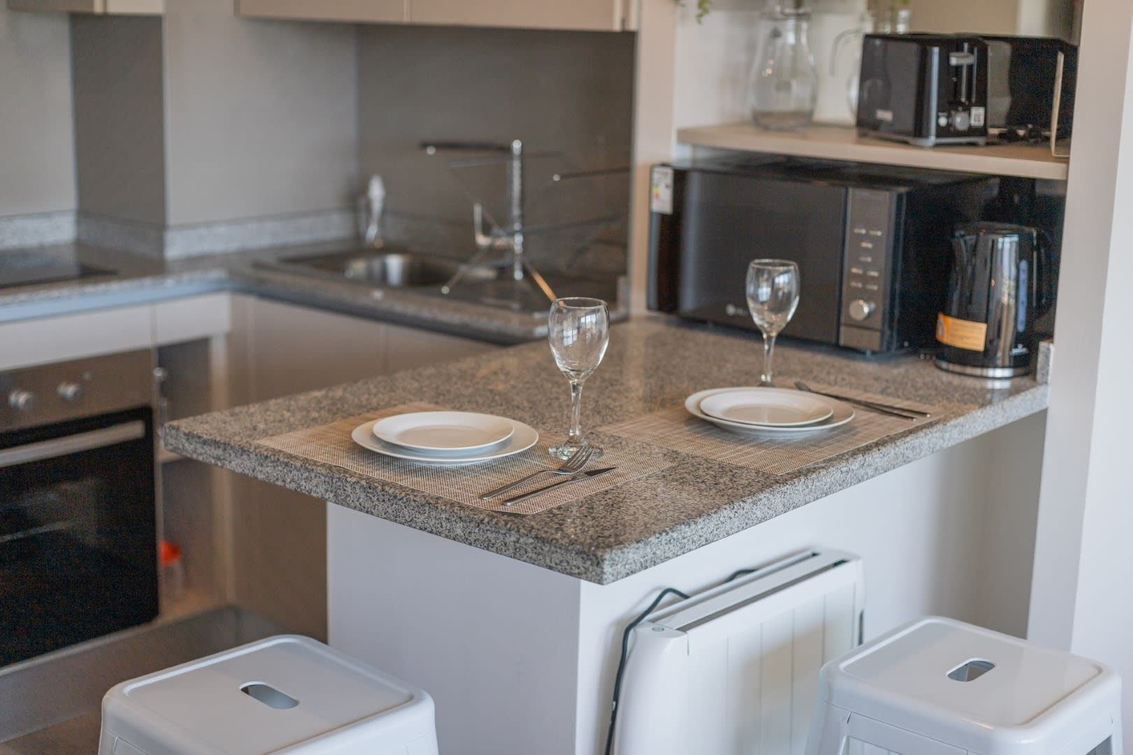 Modern kitchen with sleek appliances and cozy dining space for two.