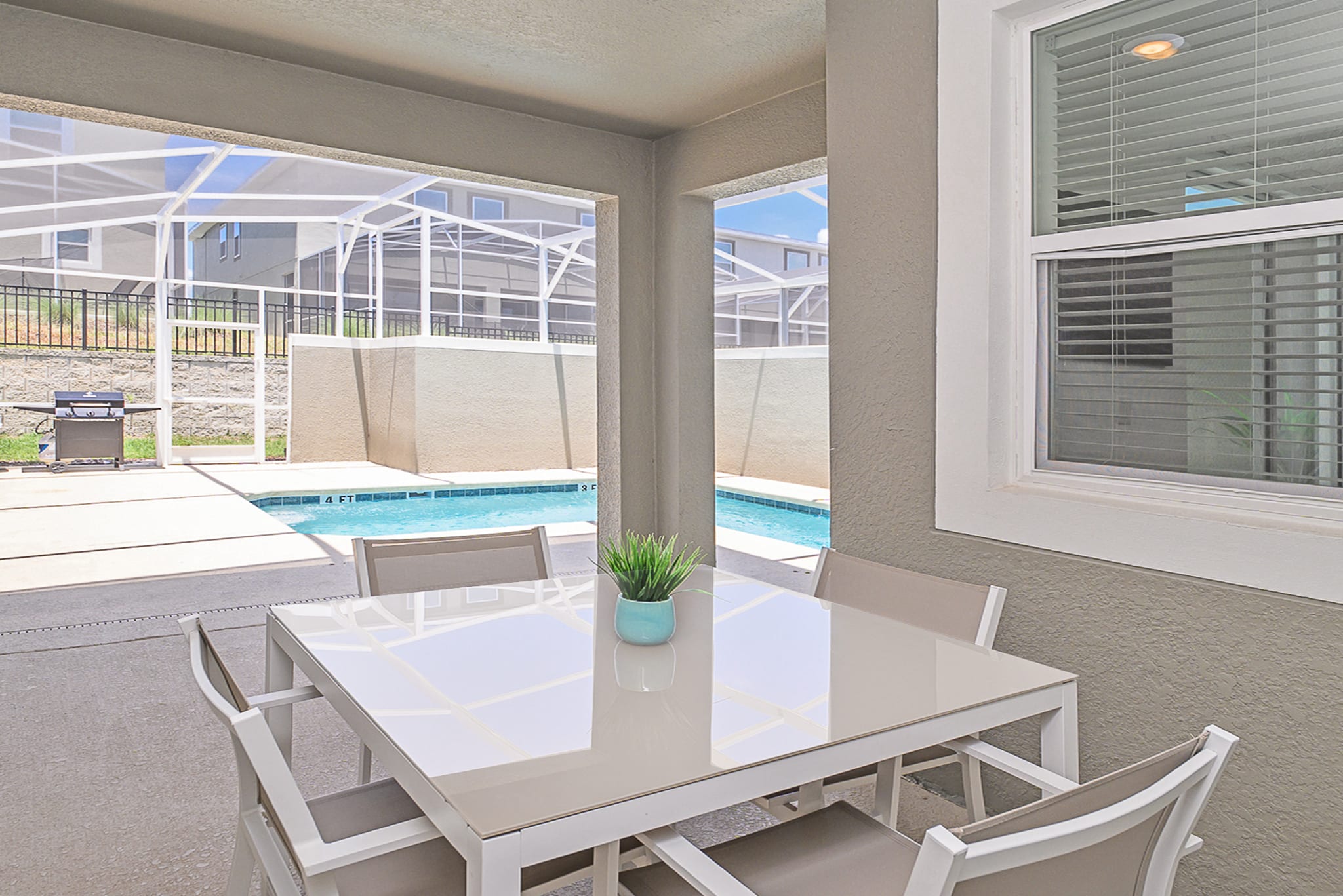 Outdoor Dining Area With Seating For Four Next To The Pool