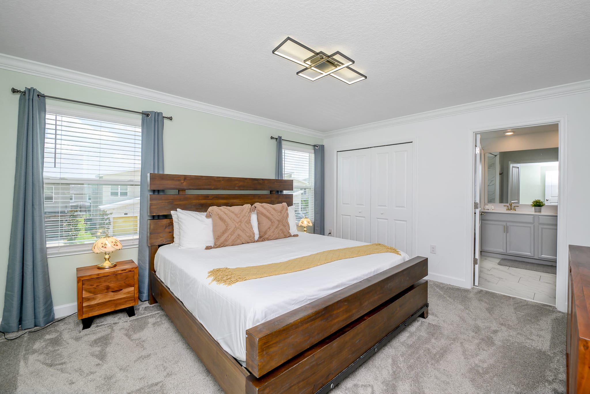 Elegant Queen Bedroom With Cozy Bedding And Ensuite Bathroom Access