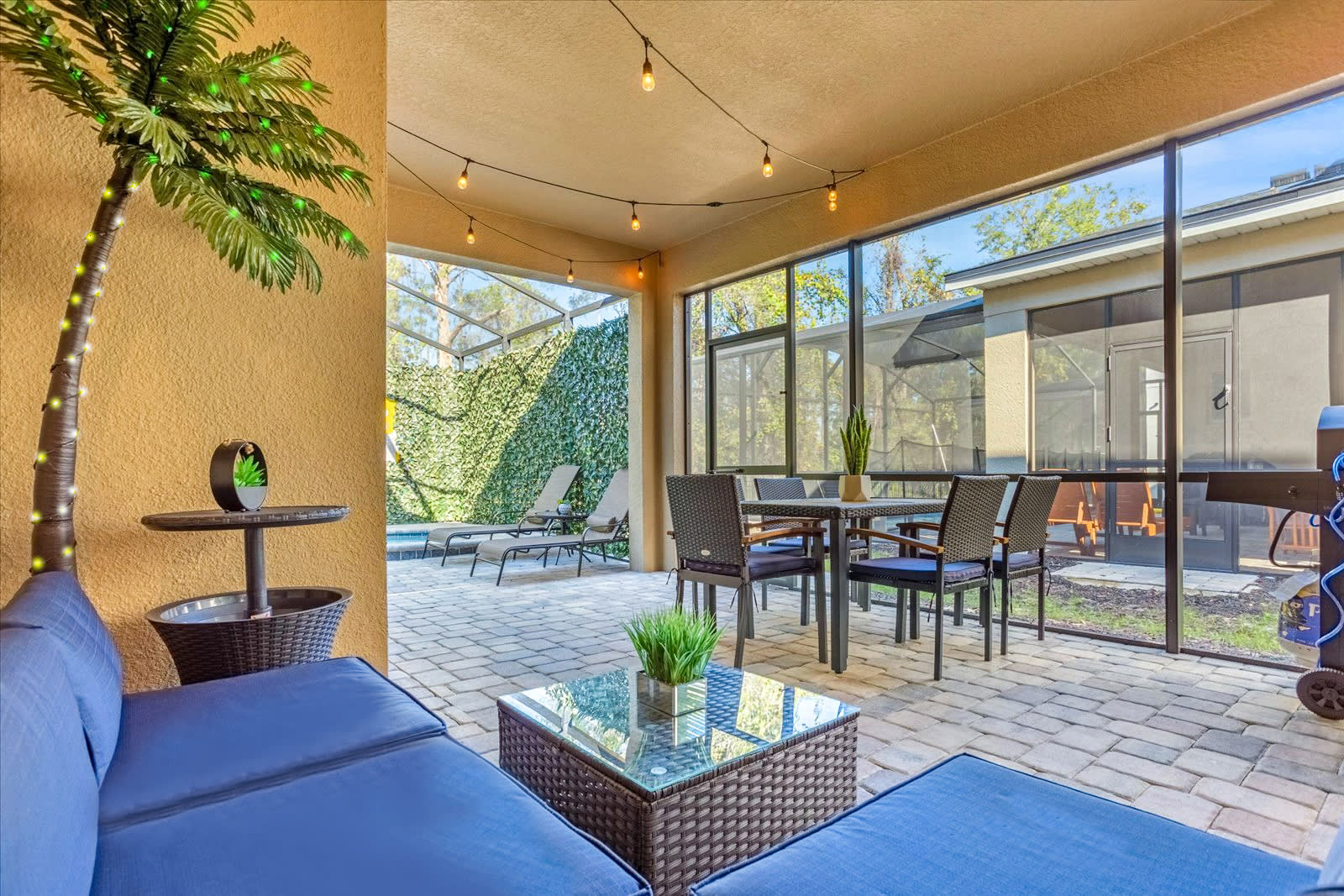 Covered outdoor lounge area with BBQ grill, perfect after a swim!