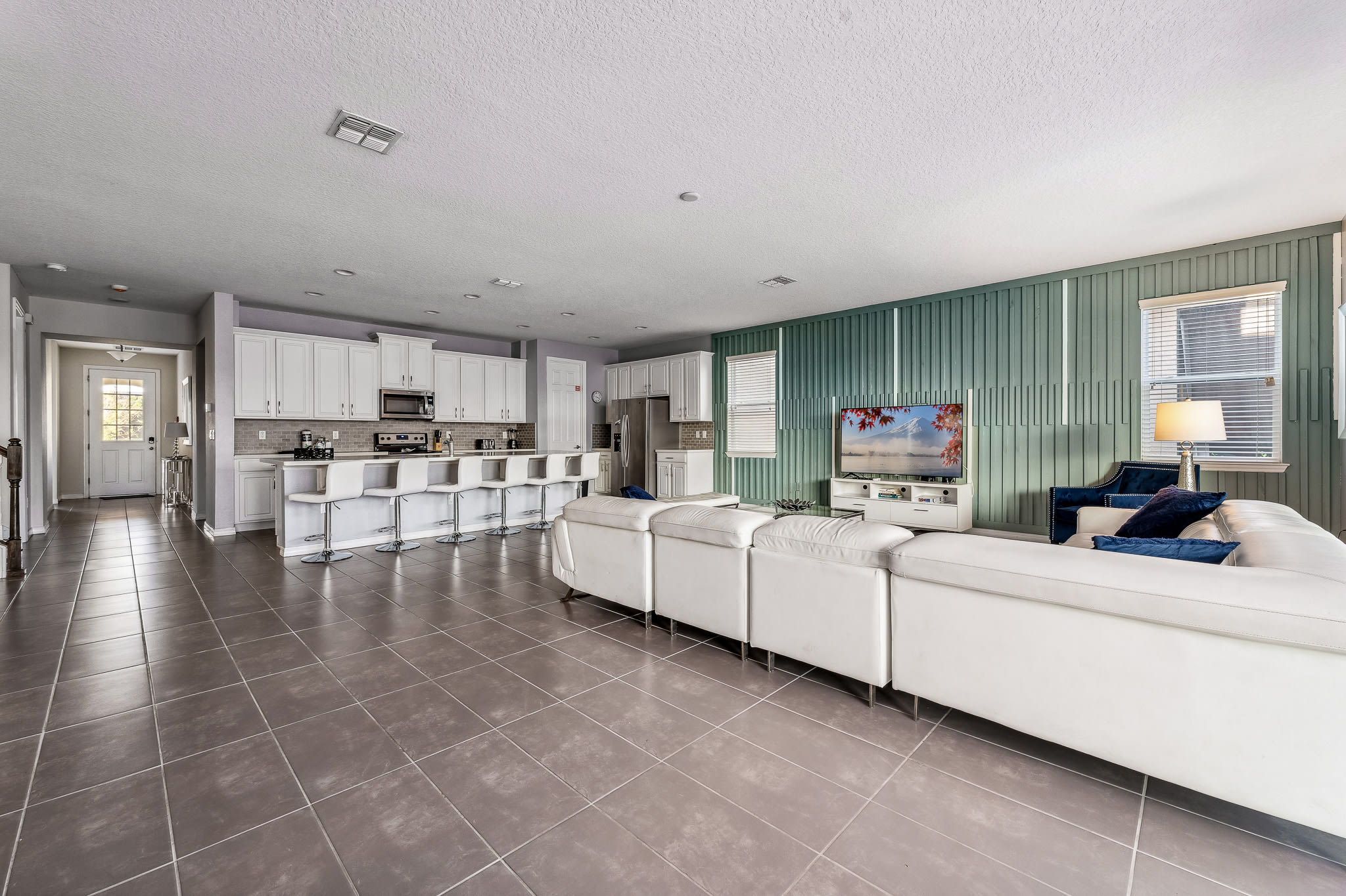 Wide living area w/ sleek floors and plenty of seating to unwind.