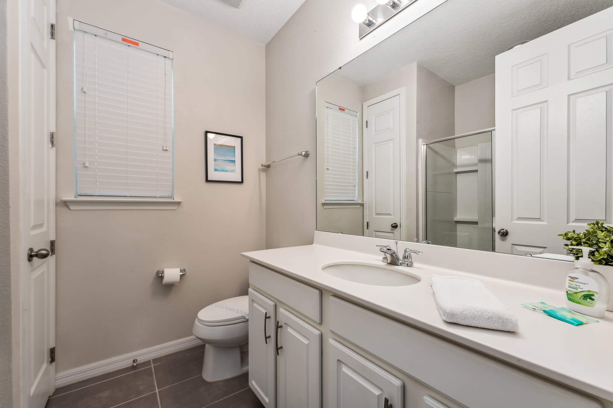 Modern bathroom w/ wide vanity and bright, neutral finishes.