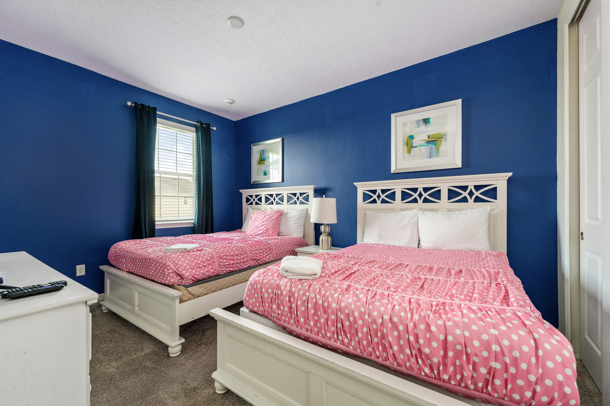 Shared kids’ room w/ twin beds and fun wall decor.