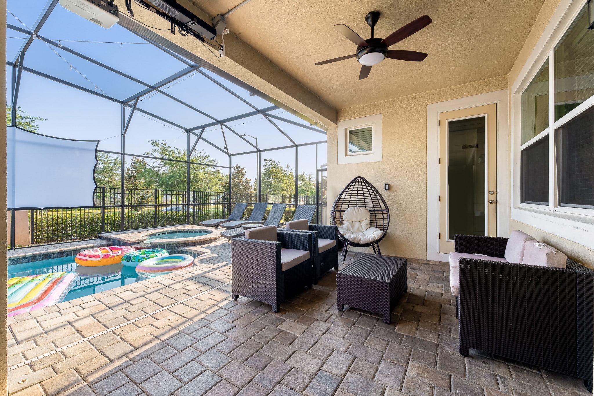 Covered patio w/ seating overlooking the pool, great for morning coffee or evening chats.