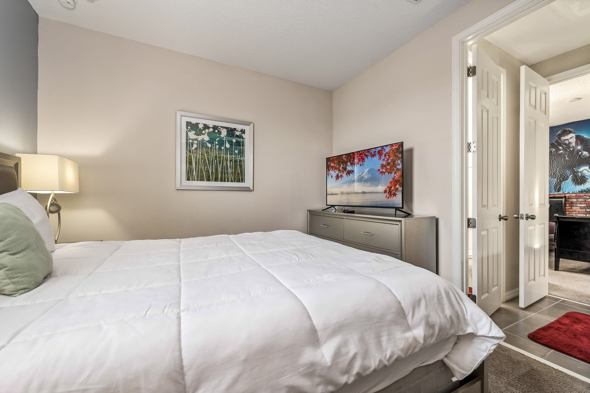 Sunlit bedroom w/ inviting bed, airy layout & a relaxed, uncluttered feel.