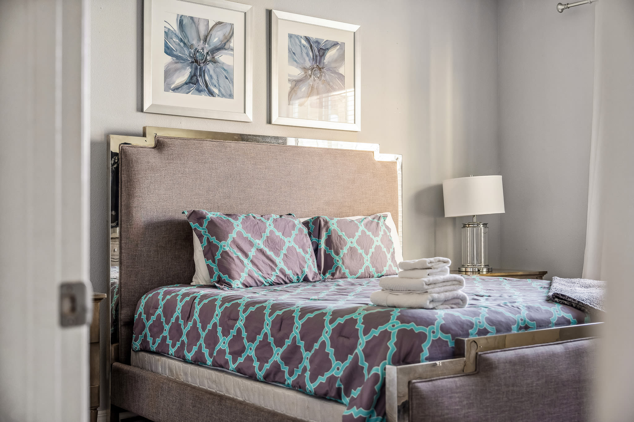 Comfortable bedroom w/ patterned textiles, warm lighting & a homey feel.
