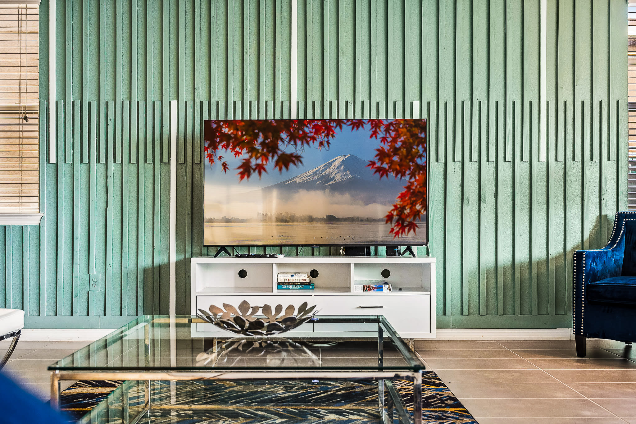 Lounge space w/ a large TV and curtains that soften the light.