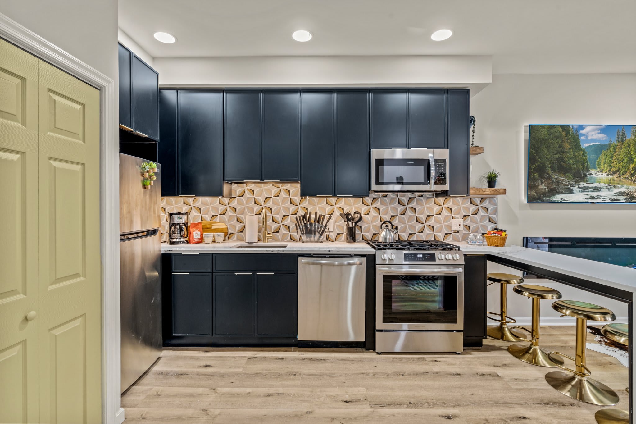 Enjoy cooking in the fully equipped kitchen, featuring modern appliances, sleek cabinetry, and a beautiful backsplash that adds a touch of elegance.