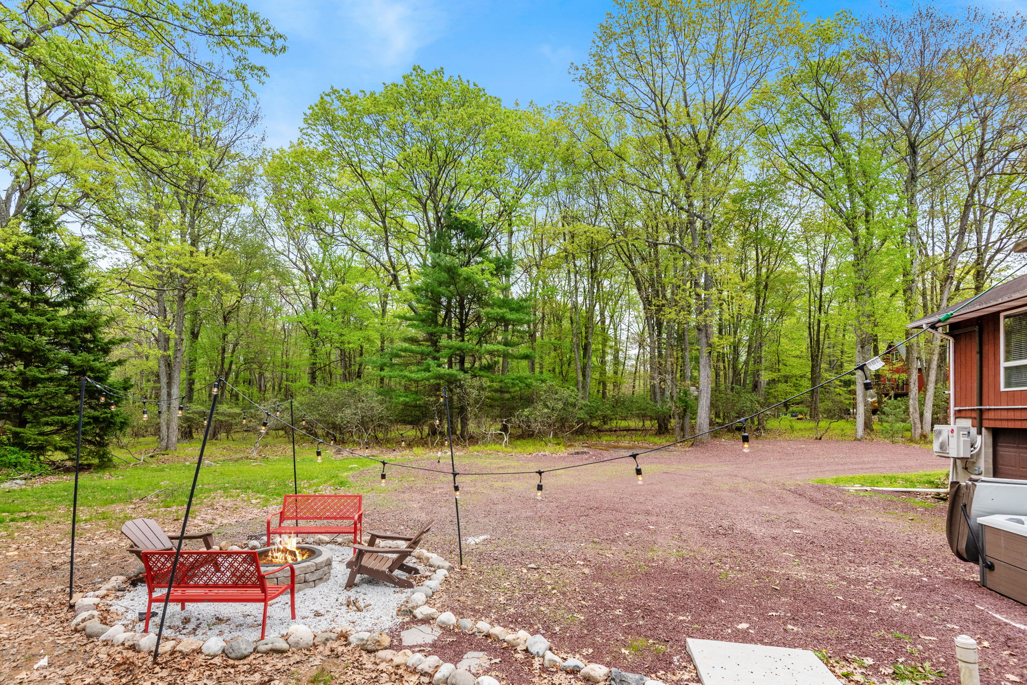 A large open yard surrounded by lush trees, offering plenty of room for outdoor activities and relaxation.