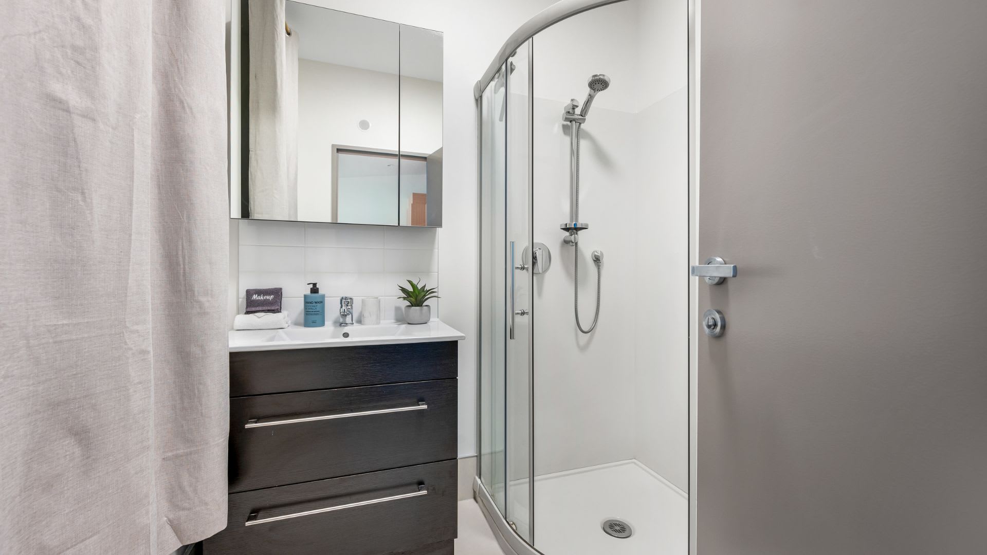 Elegant Bathroom with Modern Fixtures and Luxury Amenities – Indulge in this beautifully designed bathroom featuring a spacious walk-in shower, sleek modern fixtures, and premium toiletries for a spa-like experience.