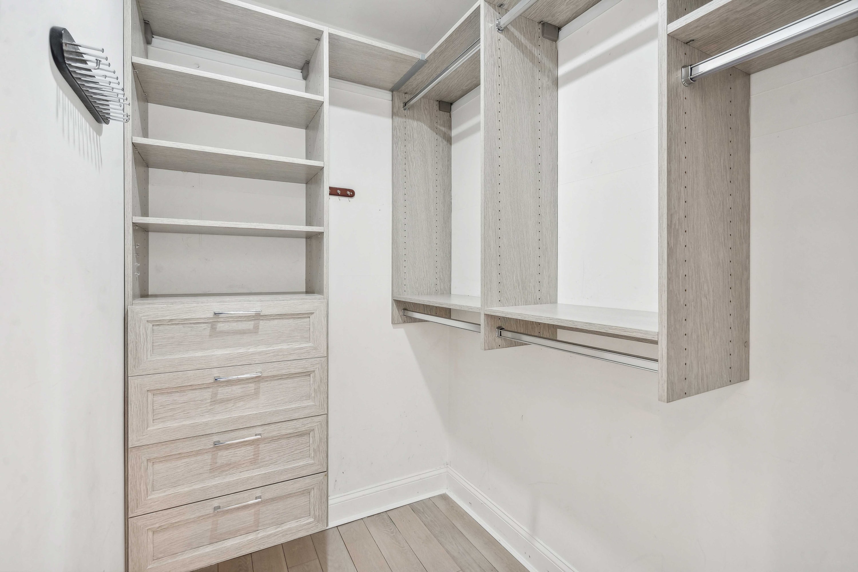 Walk-in closet with built-in shelving, hanging rods, and drawers.