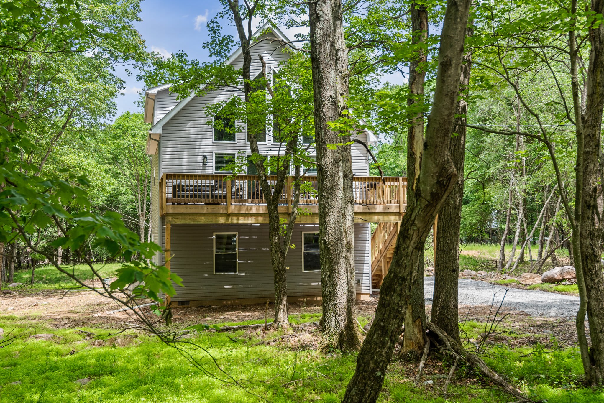 Nestled among tall trees, the rear view of the home shows off its peaceful vibe and the perfect blend of privacy and nature.