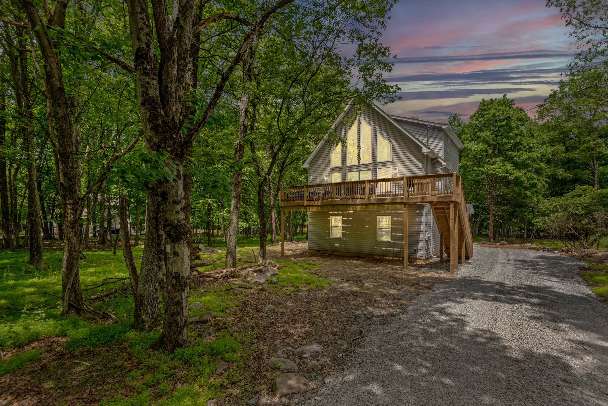 A charming A-frame nestled in the woods, where nature wraps around you and every sunset looks like it was painted just for this place.