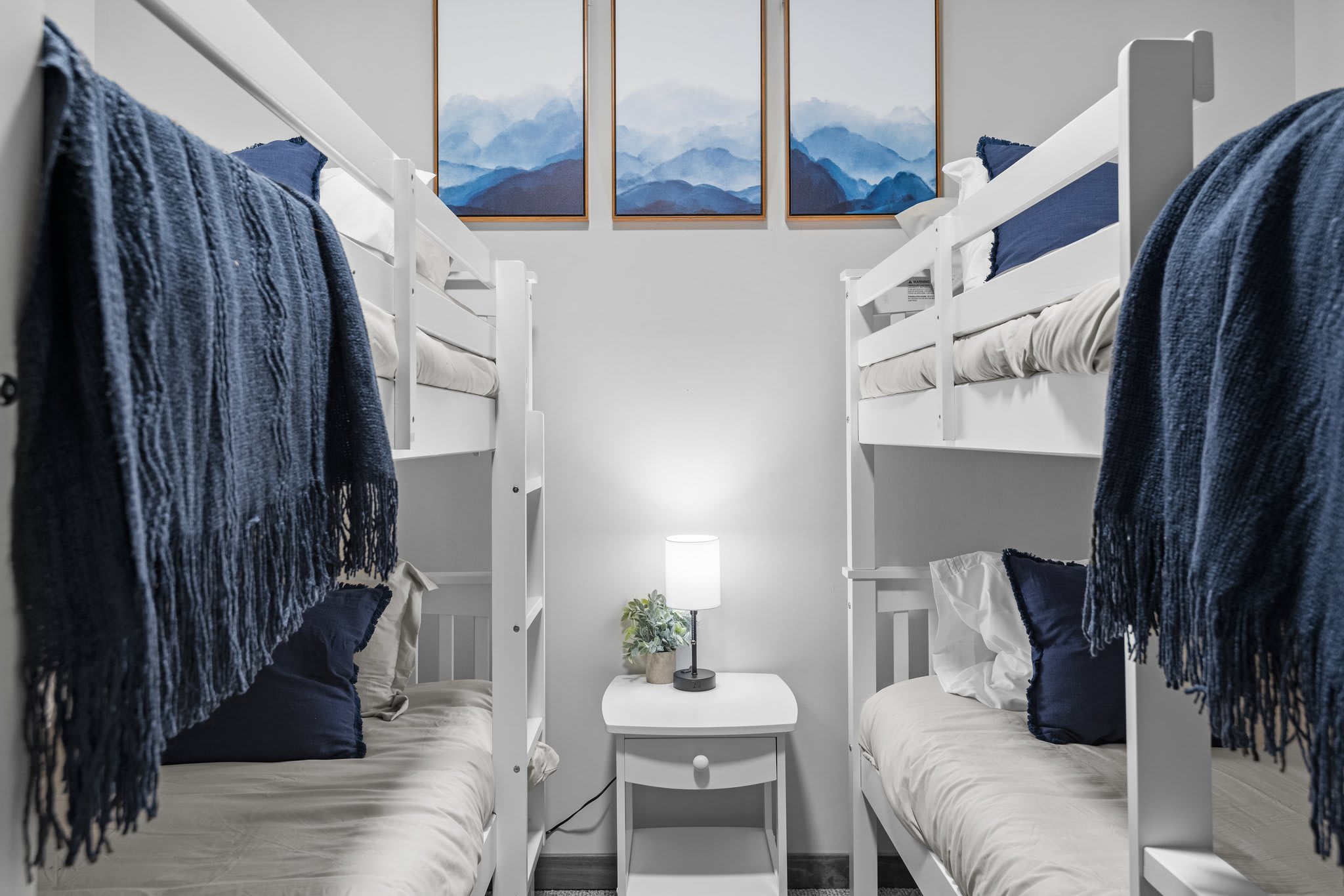 Thoughtfully designed for both style and comfort, the cozy bunk room feels like a modern camp retreat, with soft lighting and mountain artwork to tie it all together.
