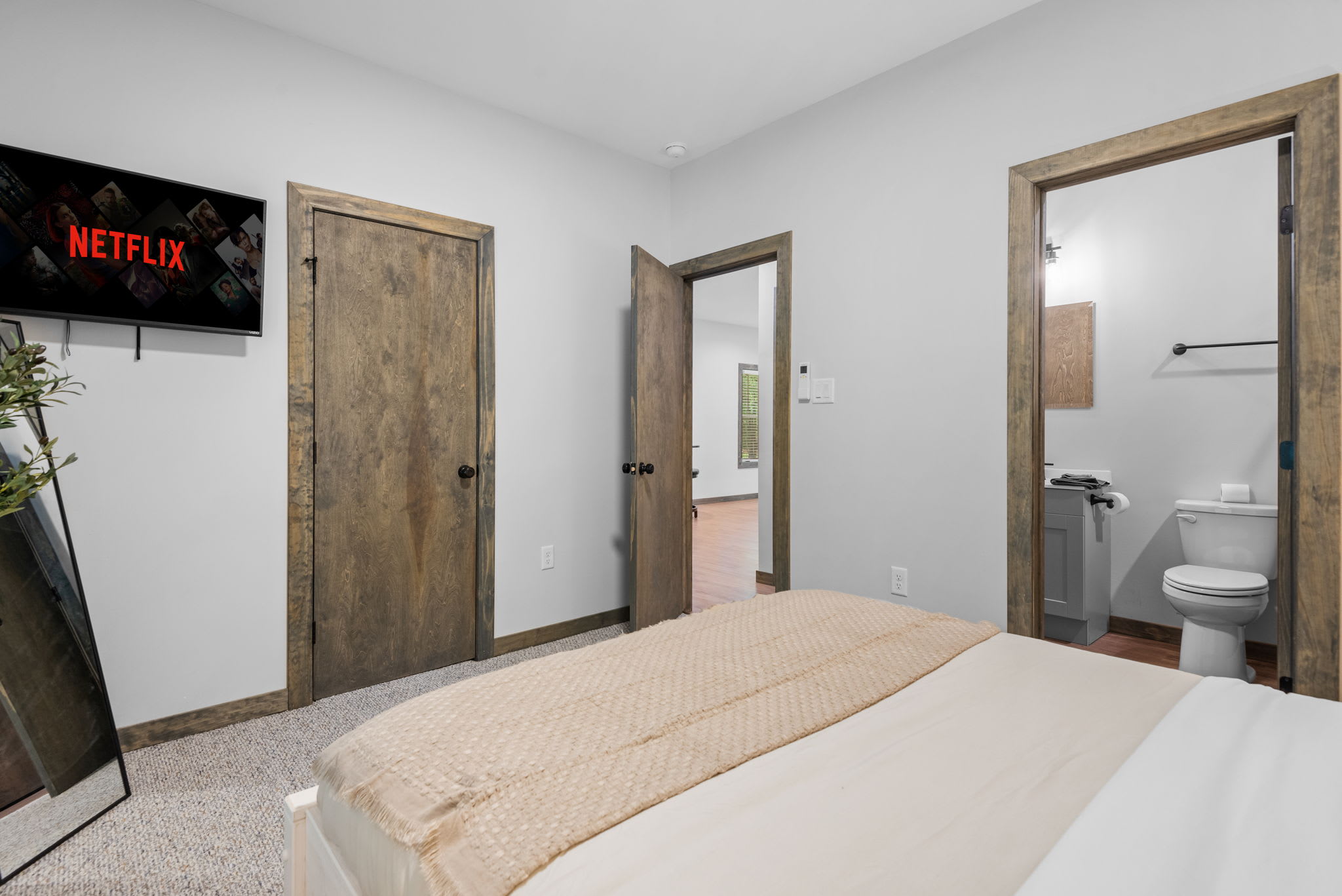 A comfy setup with a mounted TV and direct access to the bathroom, making lazy mornings and evening wind-downs extra convenient.