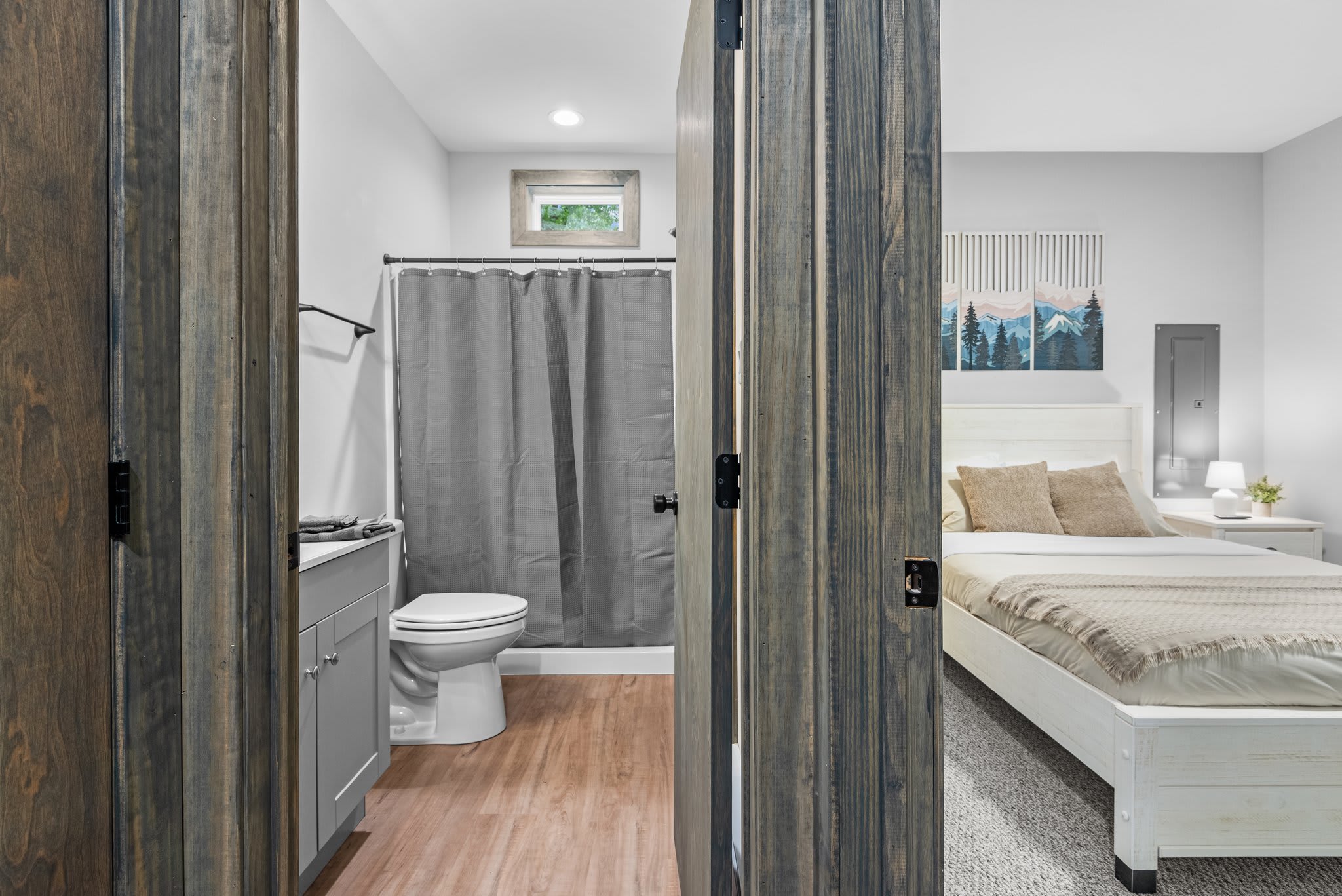 Bedroom to Bath Transition – A seamless flow from bedroom to bathroom, framed with rustic-style doors and soft neutral tones throughout.