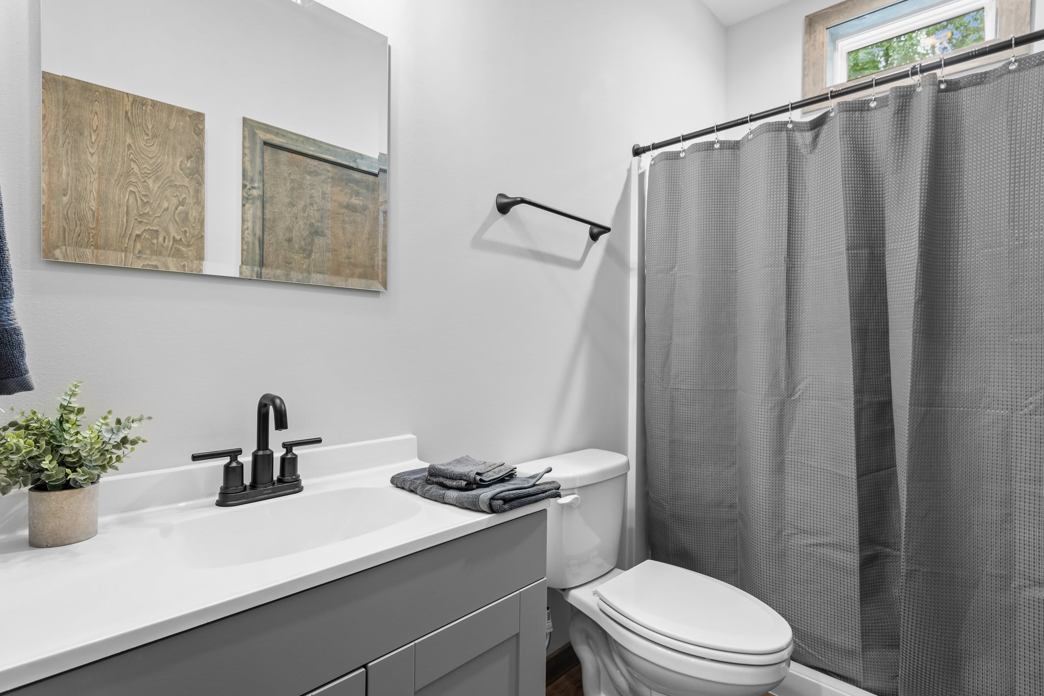 Sleek and simple with clean lines, a full tub and shower, and just the right touch of greenery for a fresh feel.