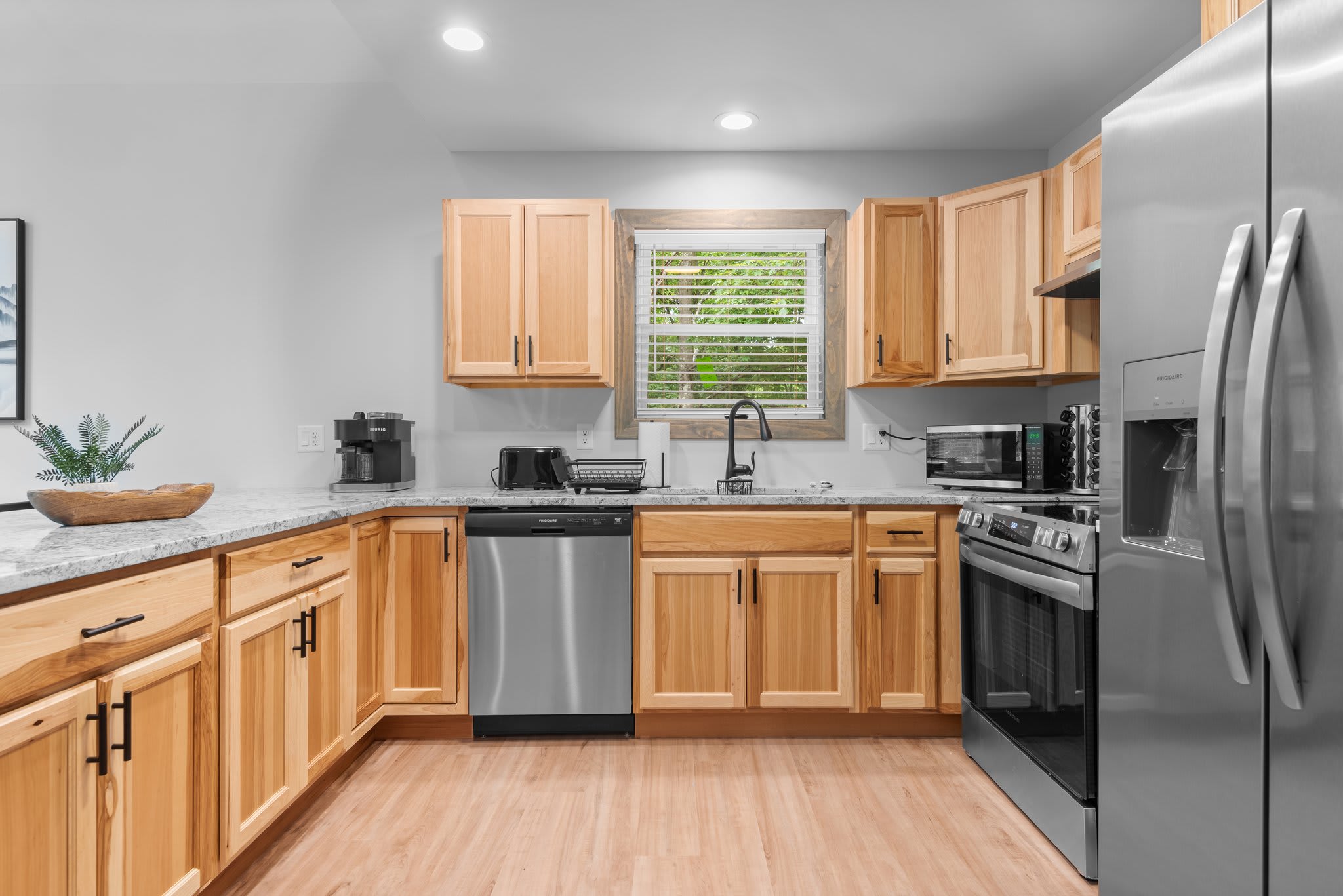 Full Kitchen View – Everything you need to cook, gather, and enjoy meals together. Stainless steel appliances, warm wood cabinetry, and natural light bring it all together.
