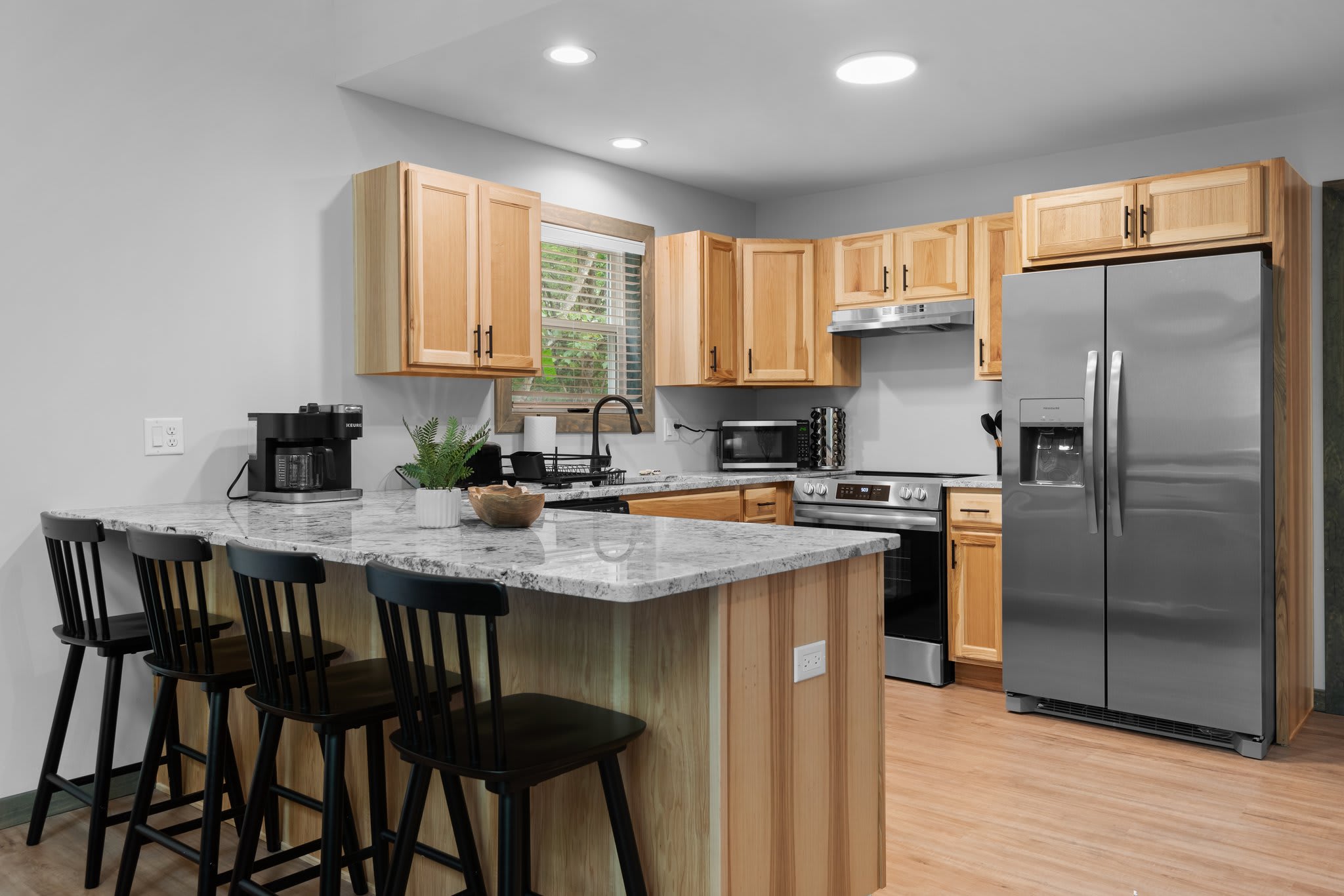 A modern kitchen hub with a spacious island and bar seating, perfect for quick bites, family chats, or late-night snacks.