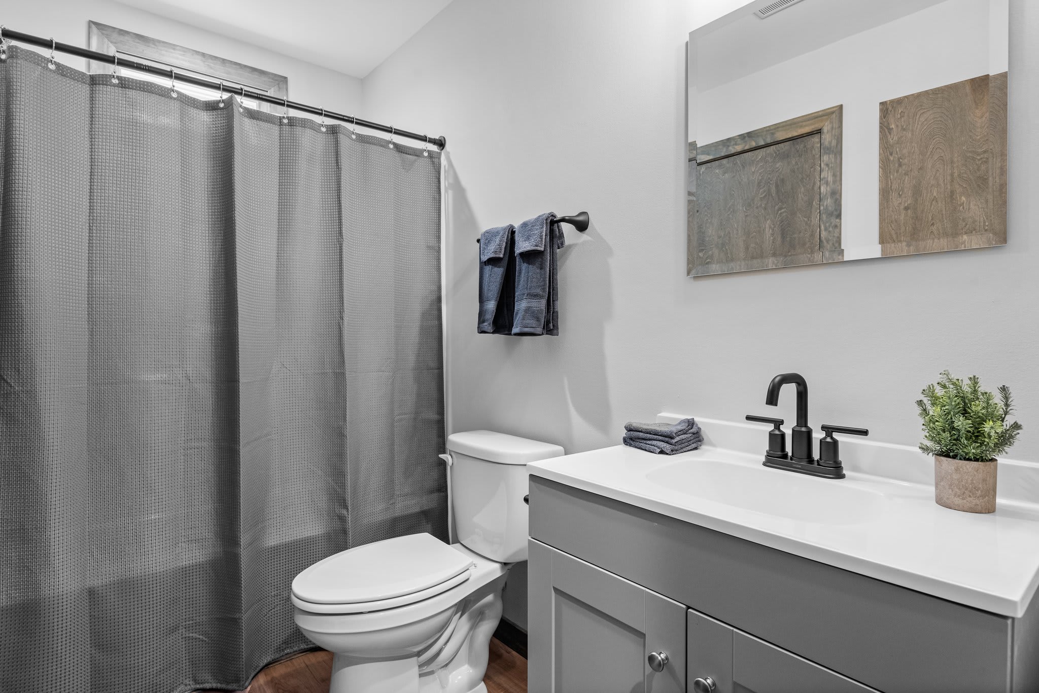 Bright and clean with bold contrast. The sleek vanity and matte black fixtures give this bathroom a fresh, updated feel.