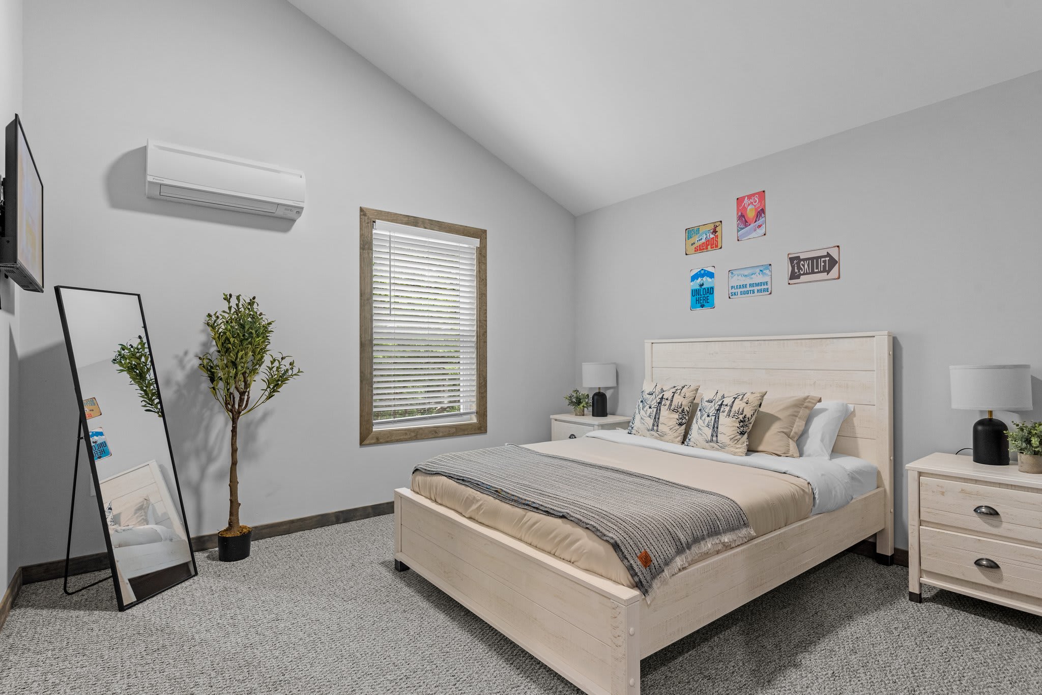 A cozy and playful space featuring fun wall art, soft bedding, and a full-length mirror to keep things practical.